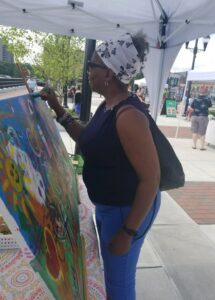 Community member adds to Mending Art canvas